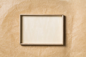 Wooden Frame over Paper Background, Empty Wood Border for Picture on Brown Papers Texture