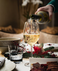 Man pours white wine into a glass