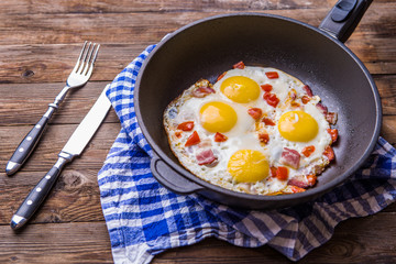 Fred eggs in pan with tomatoes.