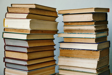 two stacks of old books in hardcover