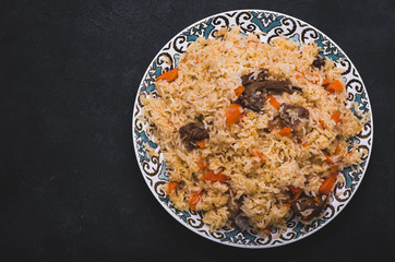 Pilaf on plate with oriental ornament. Central-Asian cuisine - Plov. Top view.