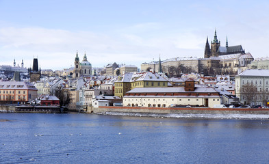 Obraz premium Snowy freeze Prague Lesser Town with gothic Castle above River Vltava, Czech republic