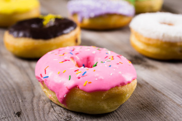 Different kinde of round donuts on wooden table. Closeup