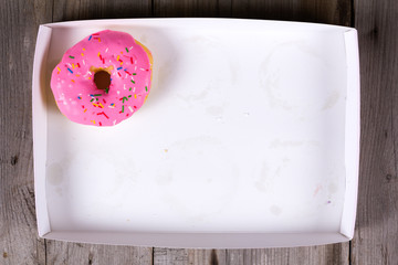 Only tasty pink donut in empty white box