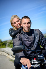 Fototapeta premium happy young biker couple riding their motorbike in summer