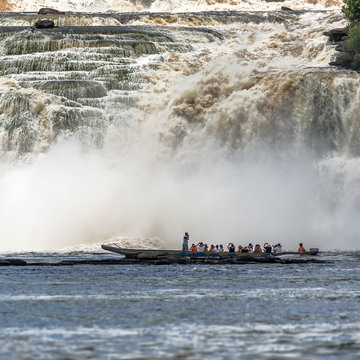 Tourists take pictures of powerful falls with tourists boat in the lagoon of Canaima national park - Venezuela, Latin America