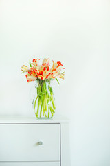 Home interior design with bunch of tulips and vase. Springtime concept