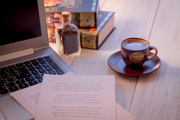 Laptop, books, cup of coffee and poems on the old wooden table. Shakespeare Poems