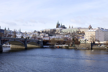 Obraz premium Snowy freeze Prague Lesser Town with gothic Castle above River Vltava, Czech republic