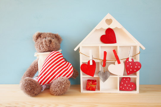 Wooden house with many hearts and cute teddy bear