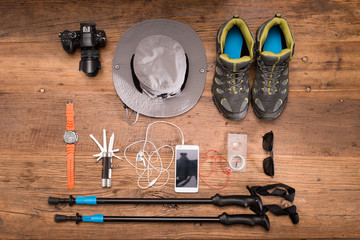 above view flat lay concept of hiking gear for travel expedition adventure on a wooden table
