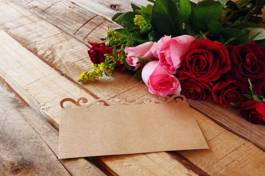 Beautiful bouquet of roses next to letter