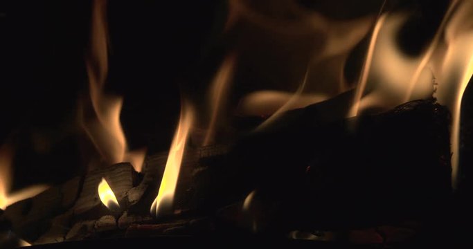 A log burner with slow flames and rising embers. Filmed in slow motion 4K