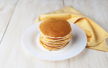 Pancake on a white plate on a wooden background