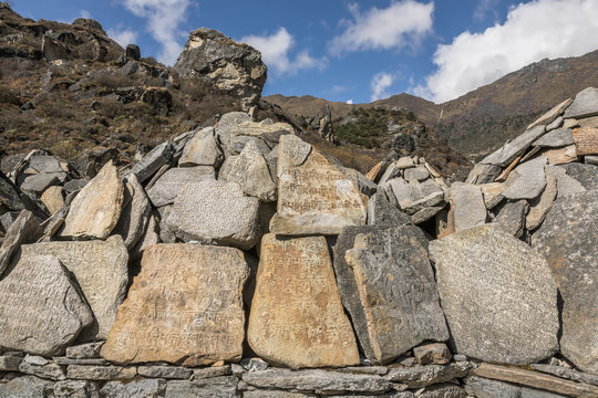 Landscape with carved stone tablets with a inscription Om Mani Padme Hum and any ancient texts - Everest region, Nepal, Himalayas