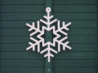 White snowflake on green wooden door