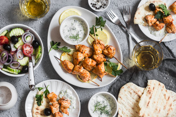 Yogurt marinated grilled chicken skewers with vegetables and tzatziki. Top view, flat lay