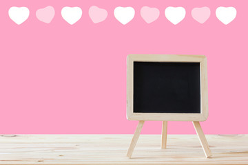 mini blackboard on wood table / mini blackboard stand with pink background and heart pattern