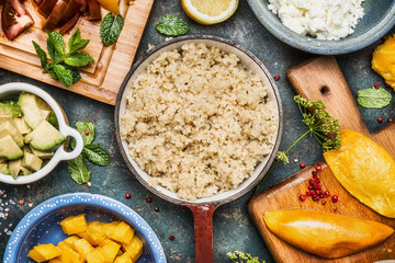 Cooked quinoa in pot with Healthy cooking ingredients, top view, close up