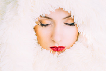 Portrait of young beautiful girl in retro style in fur, closed eyes