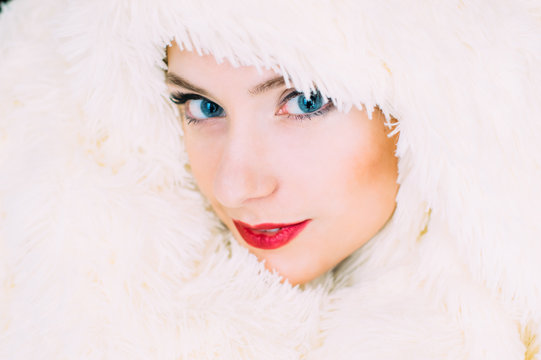 Portrait of young beautiful girl in retro style in fur, looking to the camera