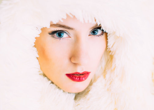 Portrait of young beautiful girl in retro style in fur, looking to the camera