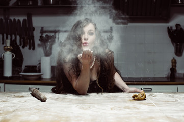 Beautiful hostess spray flour, portrait in flour fog