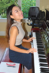 Asian female beauty playing the piano at home.