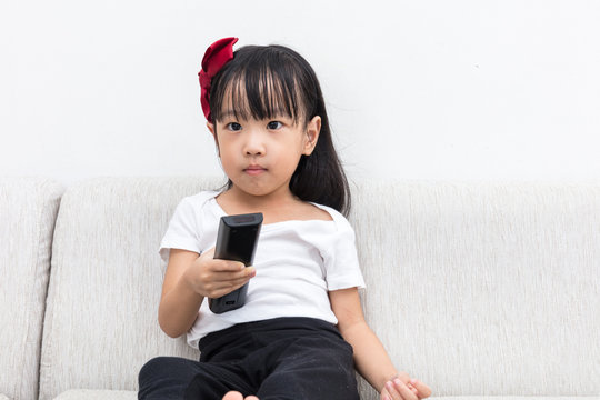 Asian Chinese little girl holding a TV remote control