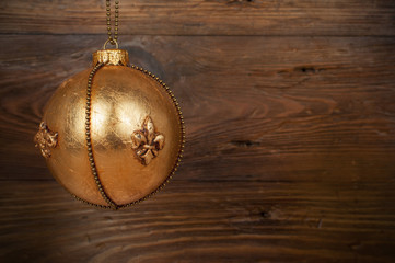 handmade golden chrostmas ball on wooden background