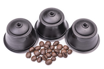 Coffee capsules and coffee beans isolated over white background