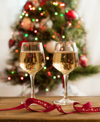 Two glasses of champagne on the table against the background of the Christmas tree