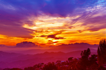 Amazing mountain landscape with colorful vivid sunset on the bright sky, natural outdoor travel background