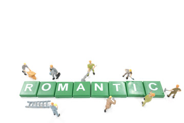 Fototapeta premium Miniature worker team building word romantic on white background