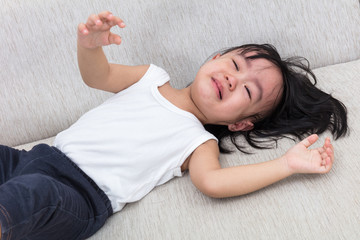 Asian Chinese little girl crying on the sofa