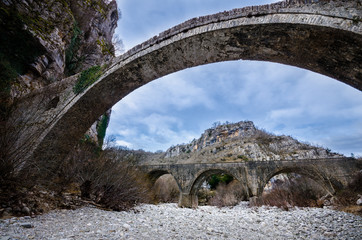 Old Noutsou - Kokkori arched stone bridge on Vikos canyon, Zagorohoria, Greece, with the new car triple arched  bridge in the background.