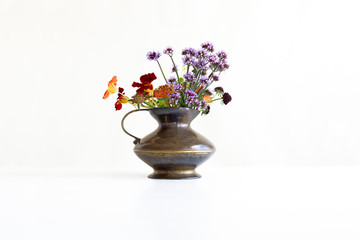 Bronze pitcher with colorful flowers