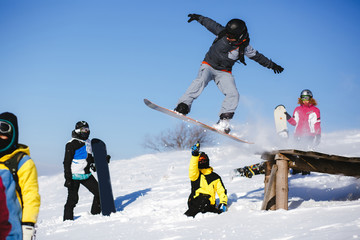 Jumping snowboarder on blue sky background