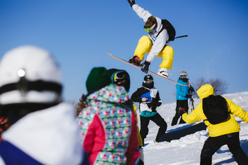 Jumping snowboarder on blue sky background