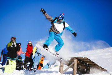 Jumping snowboarder on blue sky background