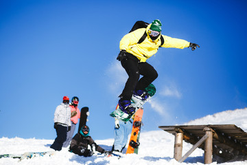 Jumping snowboarder on blue sky background