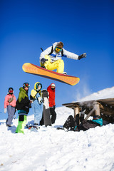 Jumping snowboarder on blue sky background