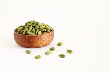 Fresh dried green cardamon seeds spice in a wooden bowl