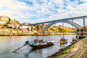 Naklejka premium A view of boats transporting Porto wine with Porto in the background, Portugal