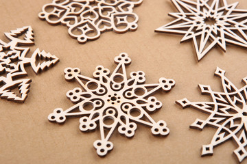 Laser cut wood snowflakes ornaments.  Wooden snowflakes on carton. - obrazy, fototapety, plakaty