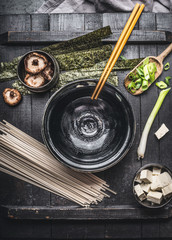 Miso soup preparation with cooking ingredients: udon noodles, tofu,  Shiitake Mushrooms , nori and...