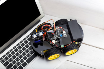 robot on four wheels with a laptop on a wooden white table