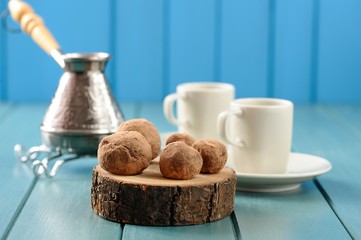 Homemade chocolate candies on wood slabs with cezve and coffee c