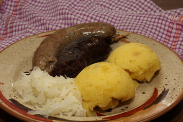 Traditional Czech specialty on a plate, sausage, black pudding, potatoes and sauerkraut - excellent