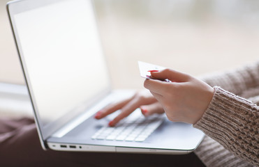 Woman hands holding credit card and using laptop. On line shopping